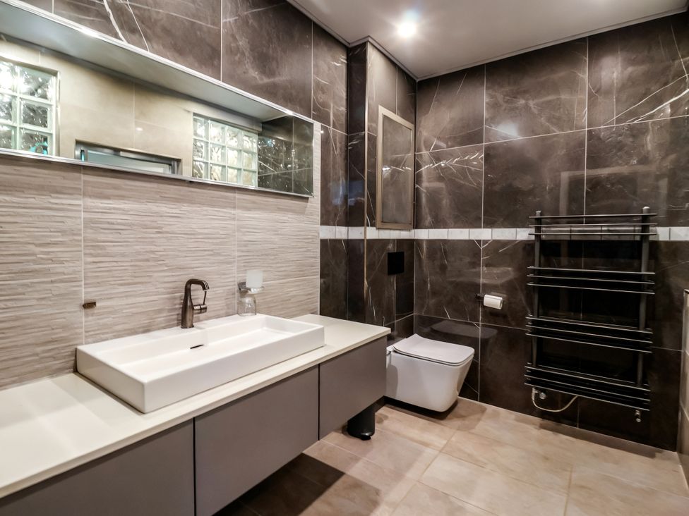 A bathroom with a sink, toilet and towel warmer at The Annexe in Shipley