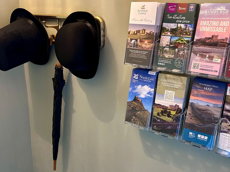 A wall with hats and brochures at Downton II Alnwick