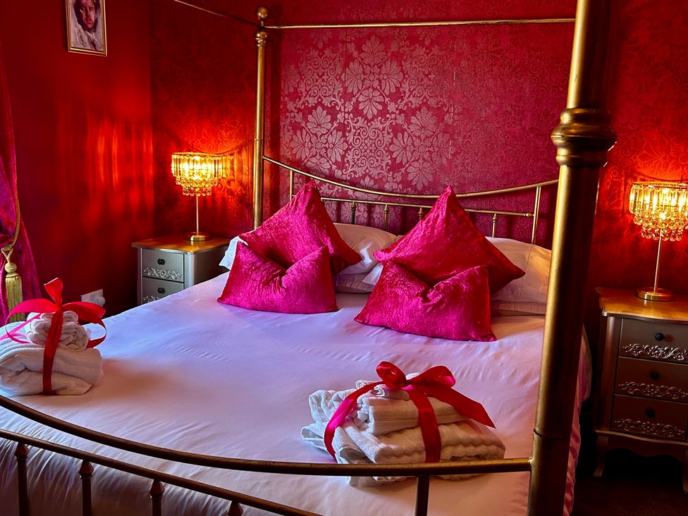 A bedroom with a bed, pillows, towels, and a lamp at Downton II in Alnwick