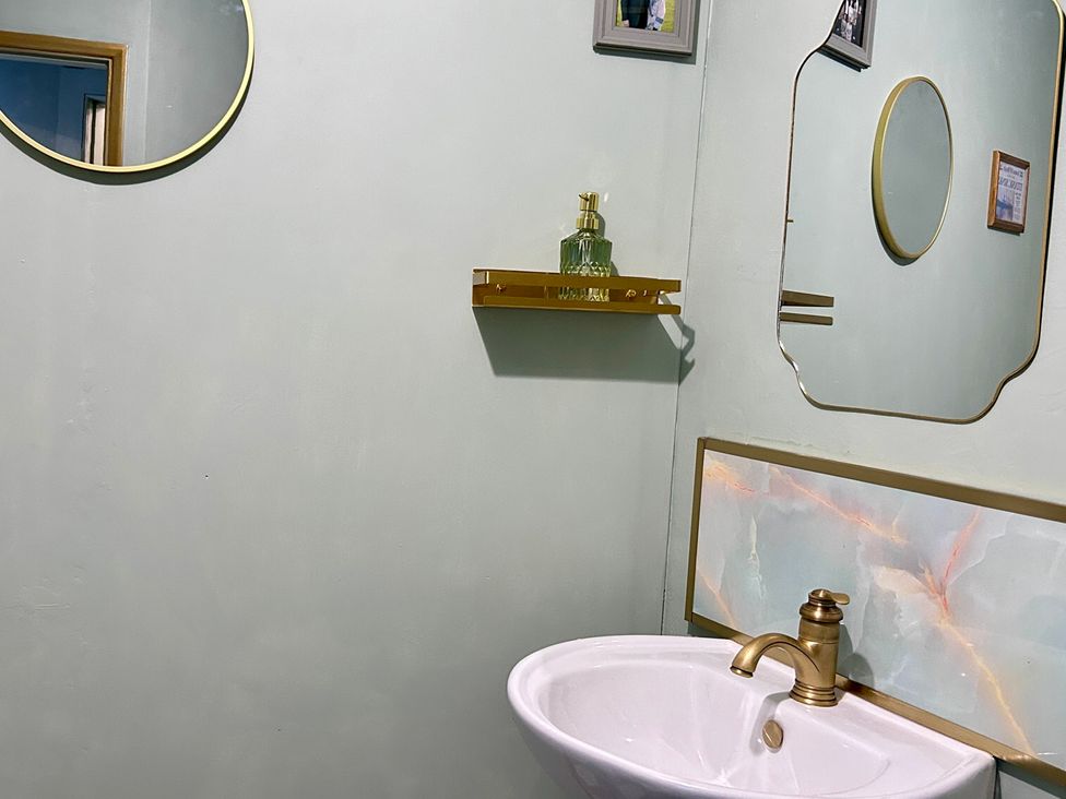 A bathroom with a sink, mirror, and shelf at Downton II in Alnwick