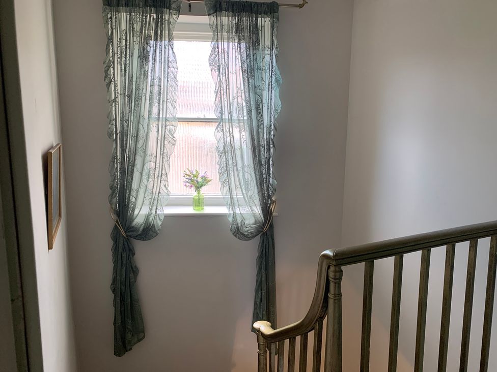 A staircase with curtains and a window at Downton II in Alnwick