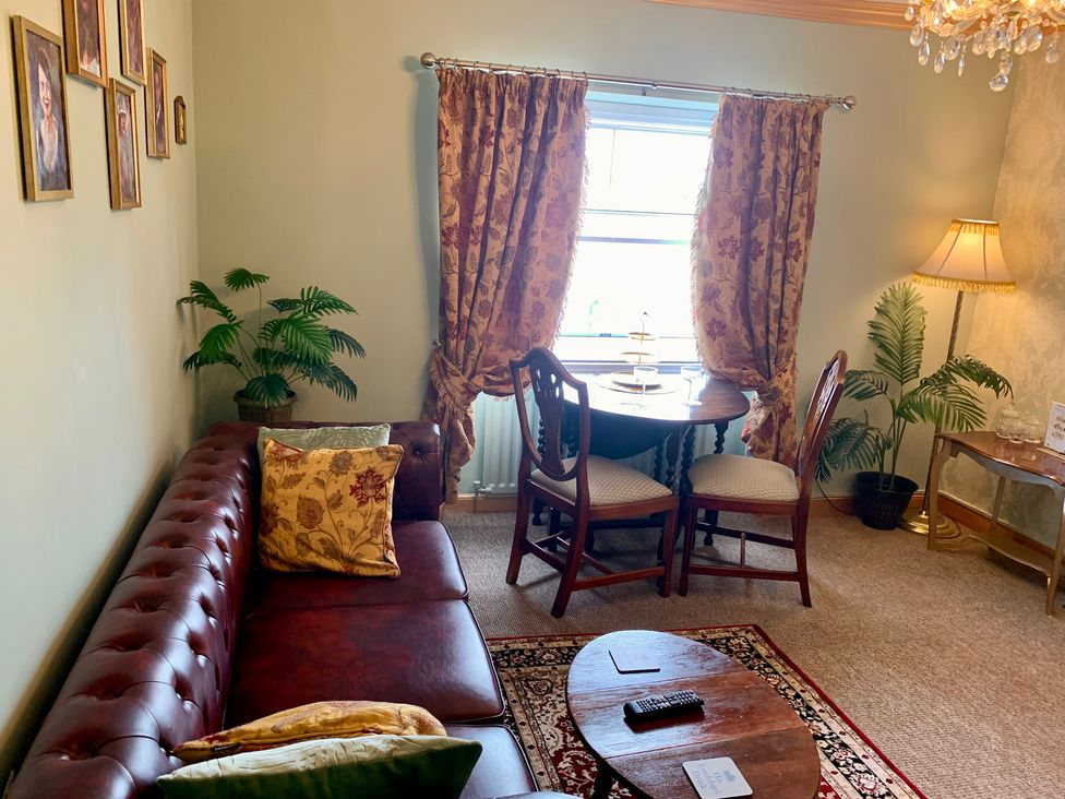 A living room with a sofa and dining table at Downton II in Alnwick