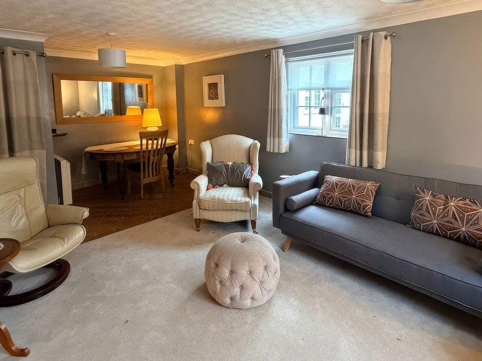 A living room with a sofa a chair and a dining table at No 1 The Martins Walberswick