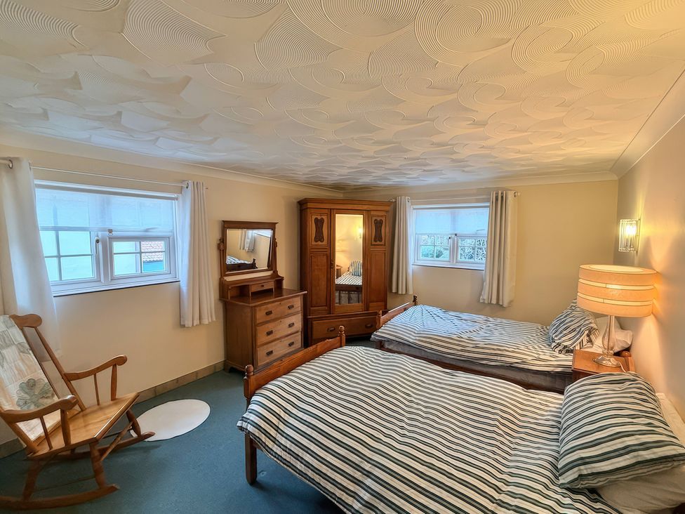 A bedroom with two beds and a dresser at No 1 The Martins in Walberswick
