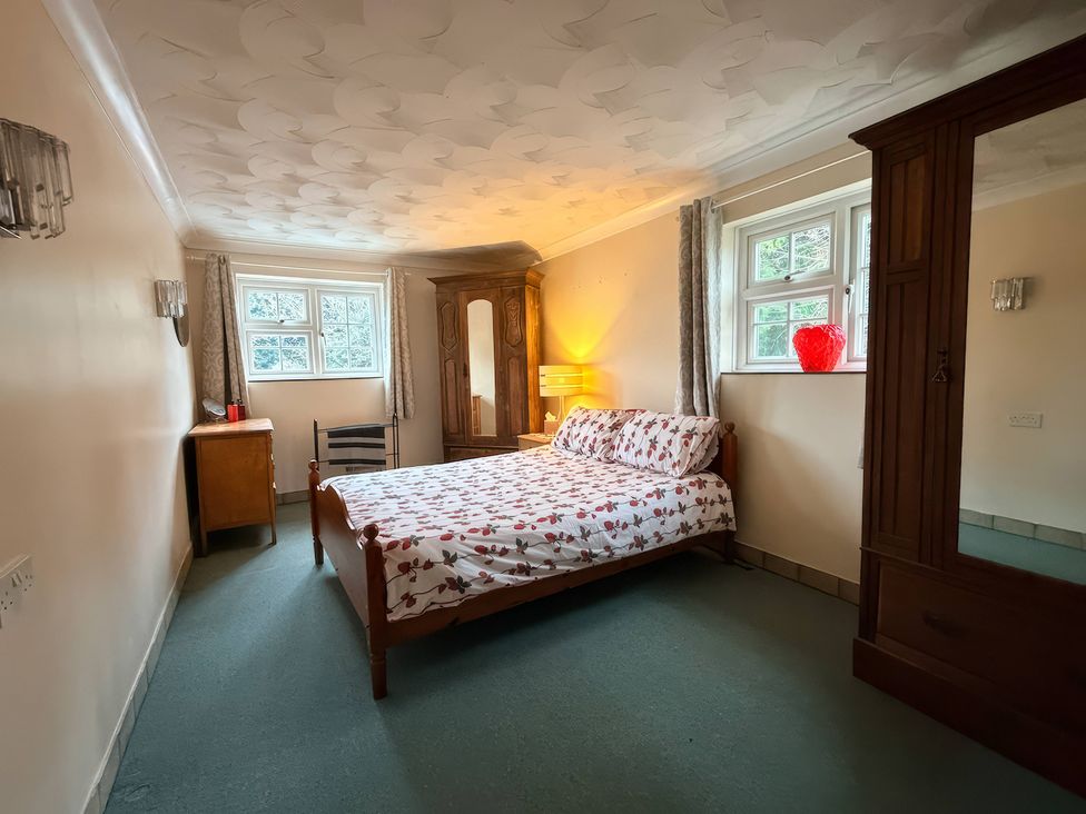 A bedroom with a bed and a mirror at No 1 The Martins Walberswick