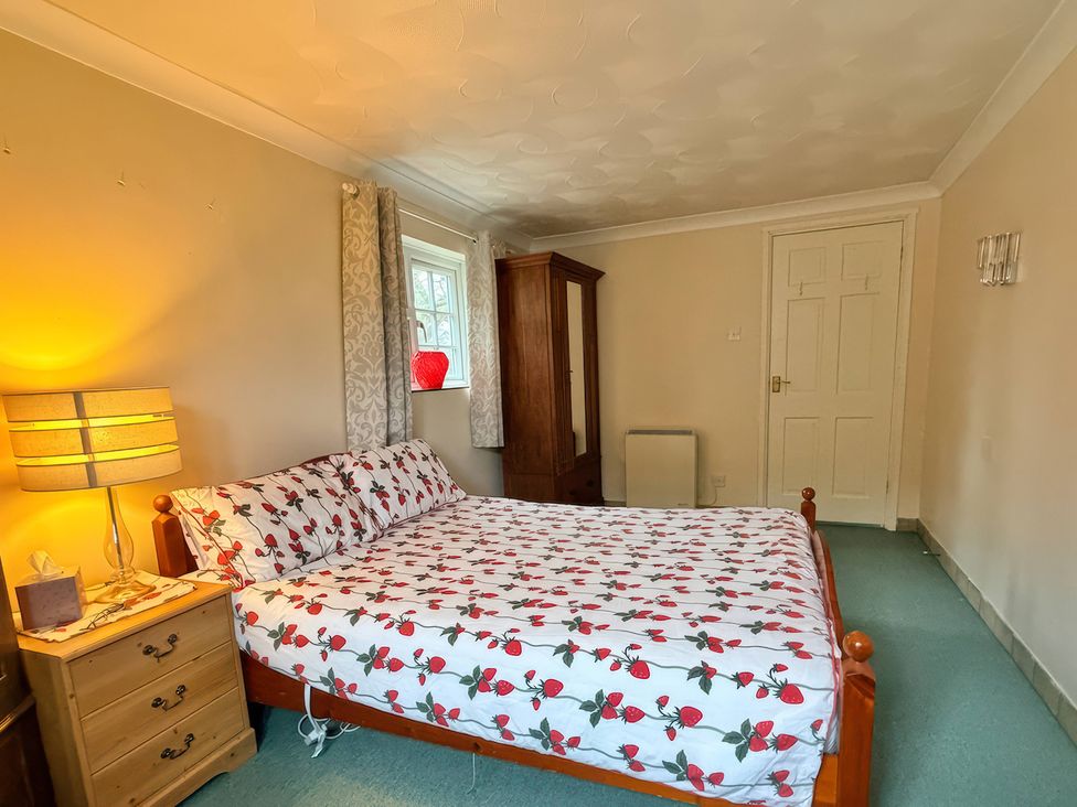 A bedroom with a bed and bedside table at No 1 The Martins Walberswick