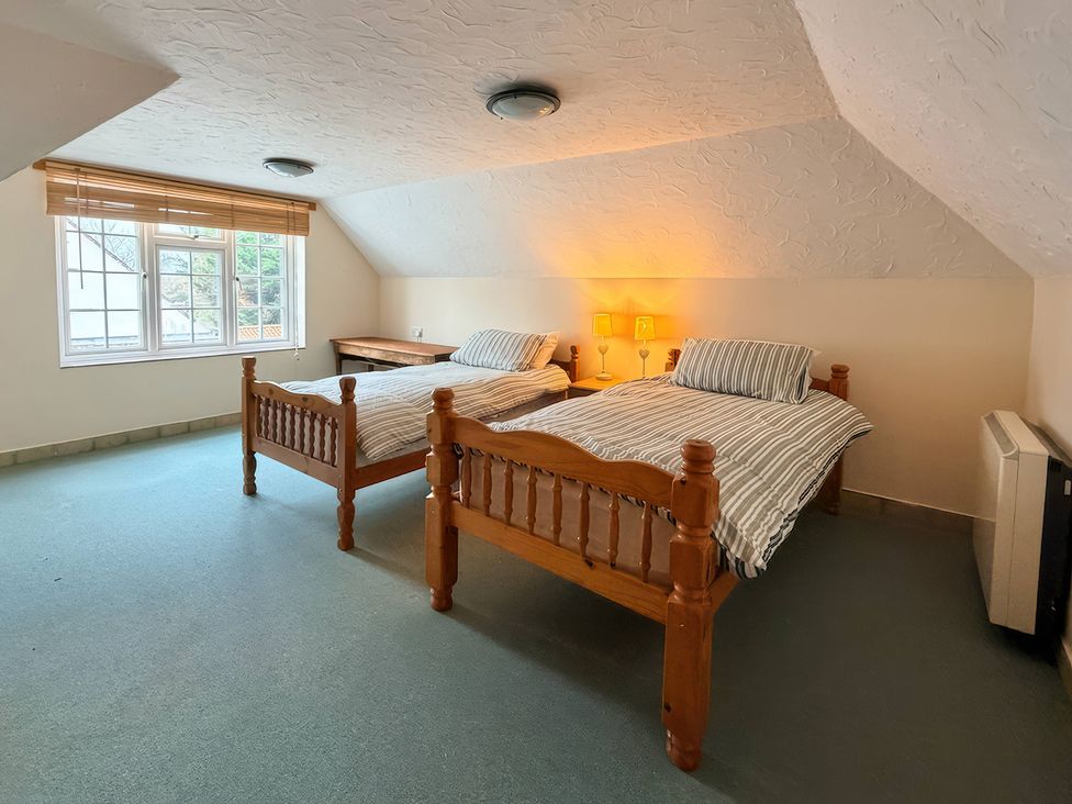 A bedroom with two beds and a window at No 1 The Martins Walberswick