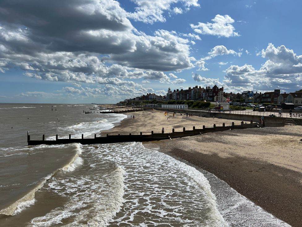 A beach with waves and people at No 1 The Martins Walberswick