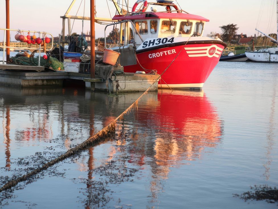 A red fishing boat named CROFTER docked at a marina in Walberswick