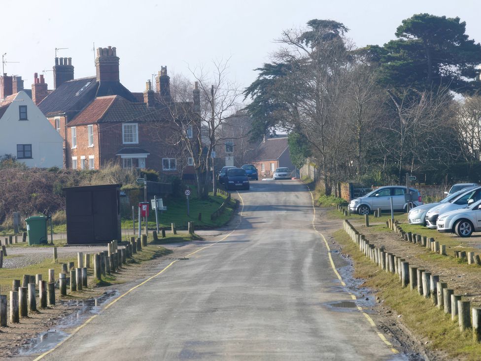 A view of a residential street with houses and parked cars at No 1 The Martins Walberswick