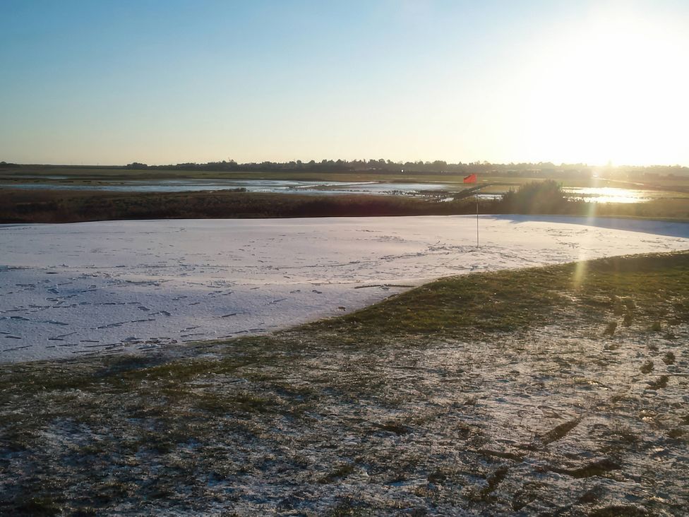 A golf course putting green with a flag at No 1 The Martins Walberswick