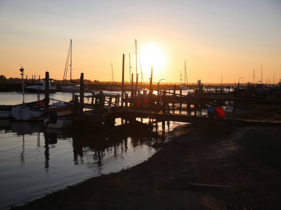 A scenic view of a marina with boats during sunset at No 1 The Martins in Walberswick