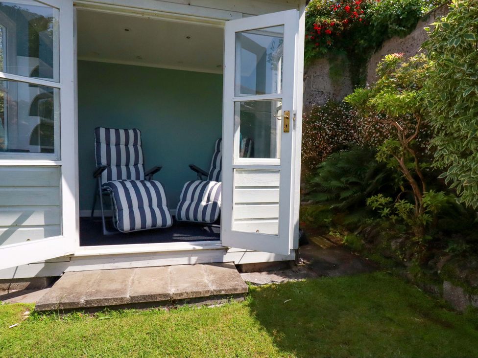 A garden with two chairs on a patio at Mary’s House