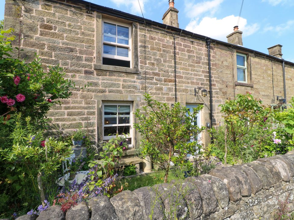 A stone cottage with flowers and plants outside at Sunnyside in Elton