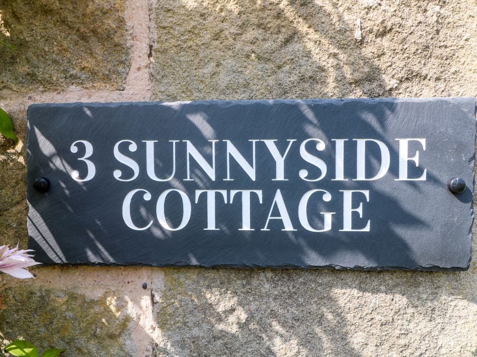 A sign that reads 3 Sunnyside Cottage on a stone wall at Sunnyside in Elton
