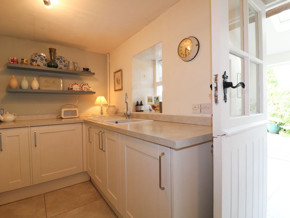 A kitchen with a sink and shelf of items at Sunnyside in Elton