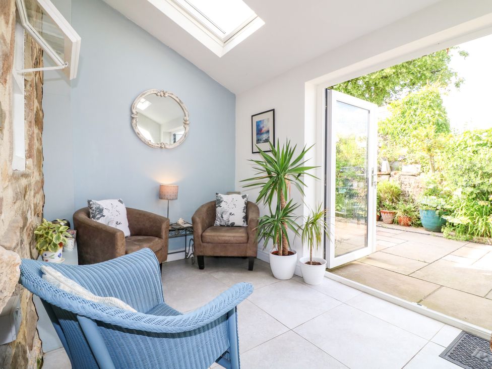 A conservatory with seating and plants at Sunnyside in Elton