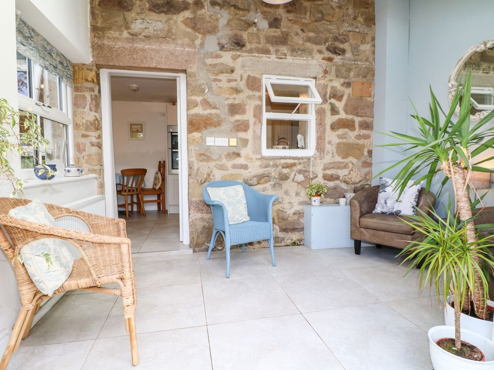 A conservatory with chairs and a table at Sunnyside in Elton