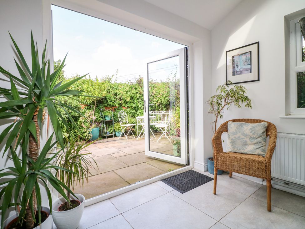 A conservatory with a chair and plants at Sunnyside in Elton