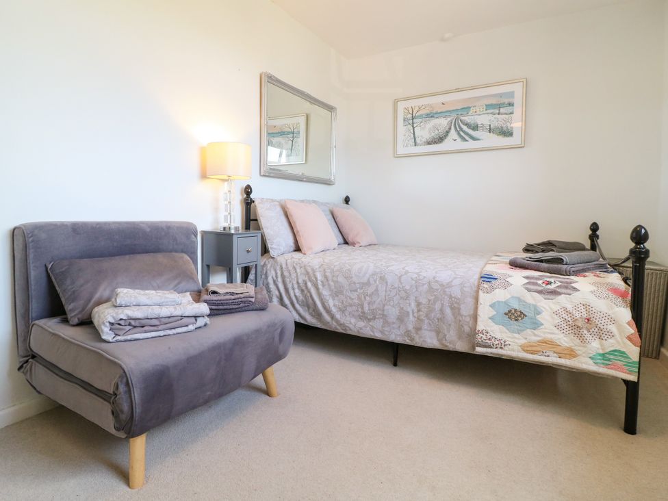 A bedroom with a bed and armchair at Sunnyside in Elton