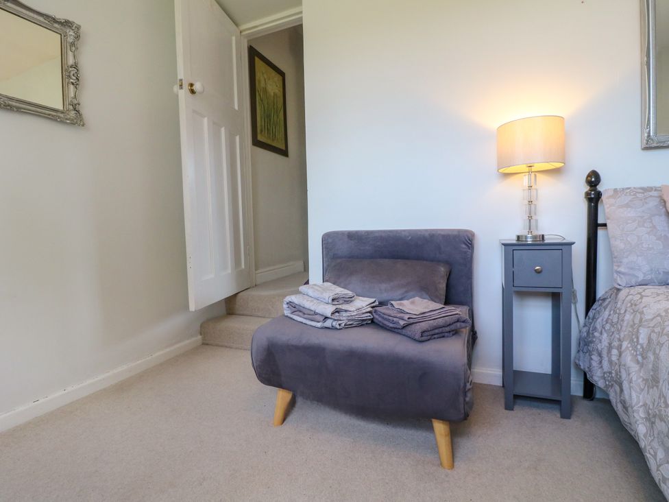 A bedroom with a chair and bedside table at Sunnyside Elton