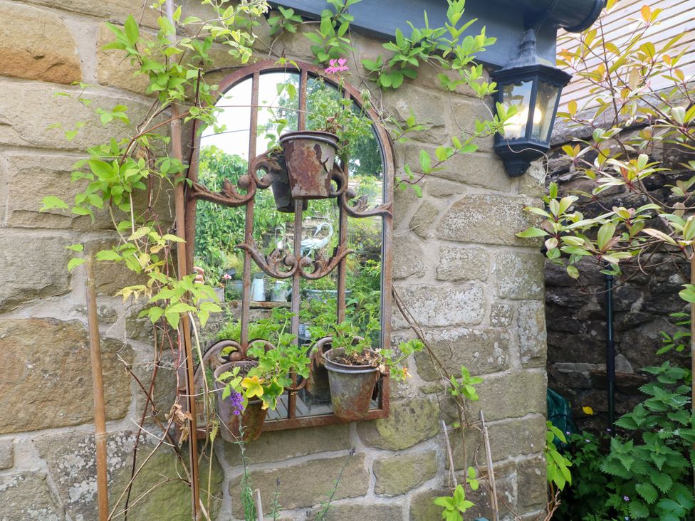 A garden feature with plant pots on a stone wall at Sunnyside in Elton