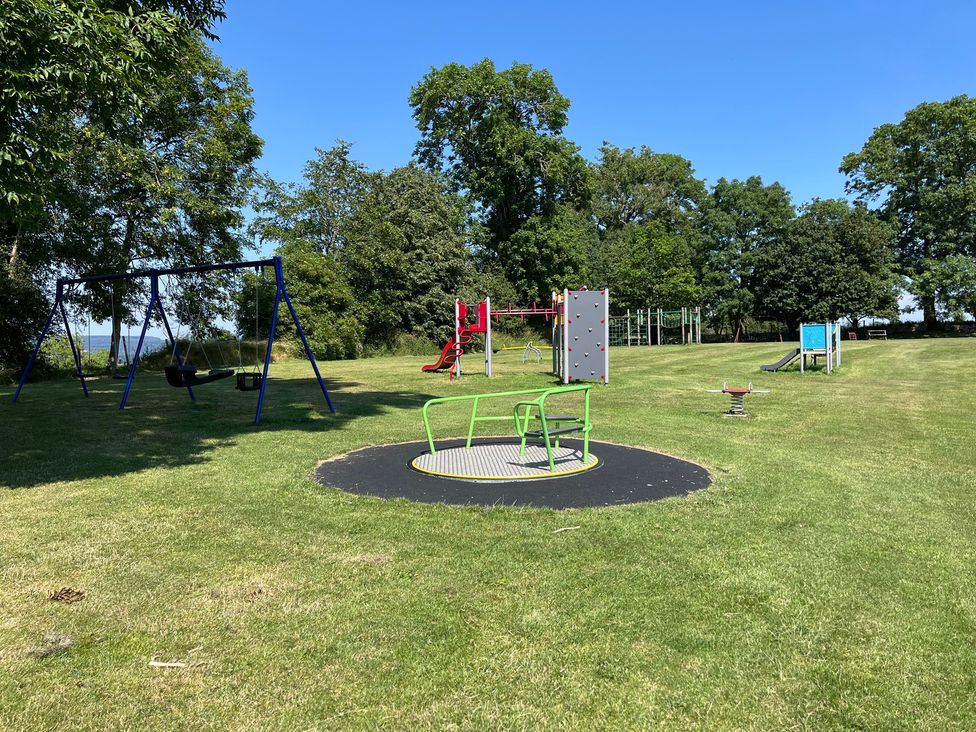 An outdoor play area with a swing set and climbing frame at Sunnyside Elton