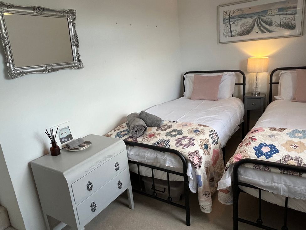 A bedroom with two beds and a bedside table at Sunnyside Elton