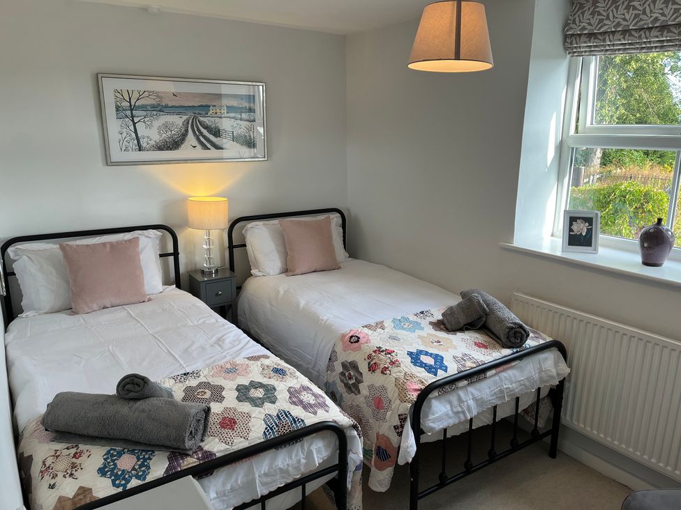 A bedroom with two single beds and a window at Sunnyside in Elton