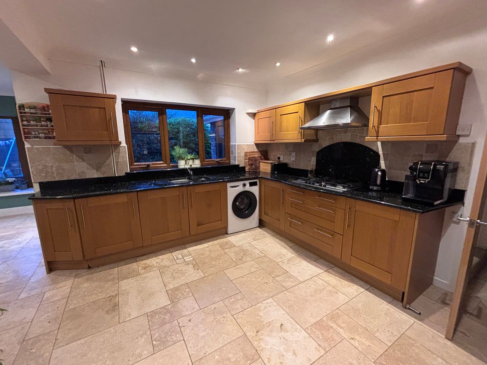 A kitchen with cabinets, a sink, and appliances at 7 Adrian Close Porthcawl