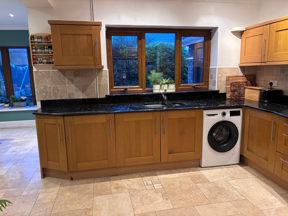 A kitchen with a sink and washing machine at 7 Adrian Close in Porthcawl