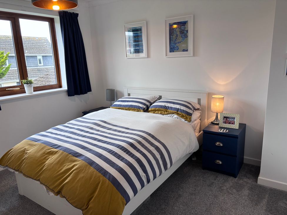 A bedroom with a bed and nightstand at 7 Adrian Close in Porthcawl