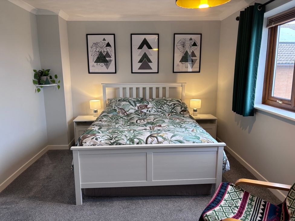 A bedroom with a bed and wall art at 7 Adrian Close in Porthcawl