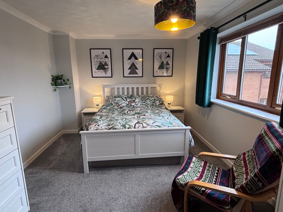 A bedroom with a bed and artwork on the wall at 7 Adrian Close in Porthcawl