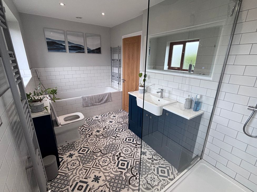 A bathroom with a bathtub, toilet, and sink at 7 Adrian Close in Porthcawl