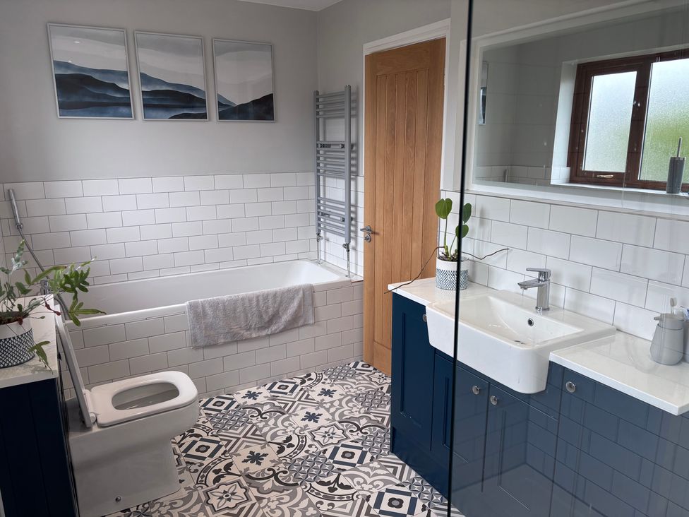 A bathroom with a bathtub and sink at 7 Adrian Close Porthcawl