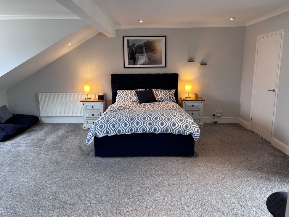 A bedroom with a bed and nightstands at 7 Adrian Close in Porthcawl