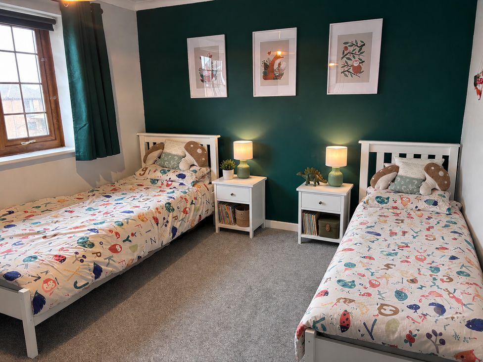 A bedroom with two beds and nightstands at 7 Adrian Close in Porthcawl