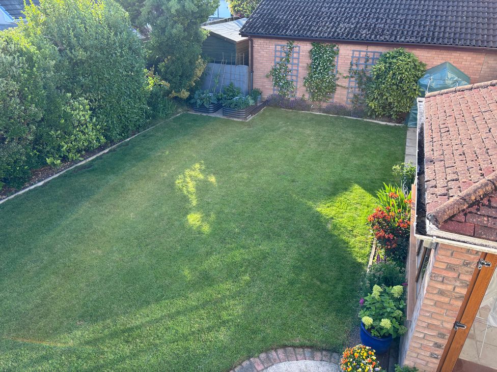 A garden with grass and flower beds at 7 Adrian Close Porthcawl