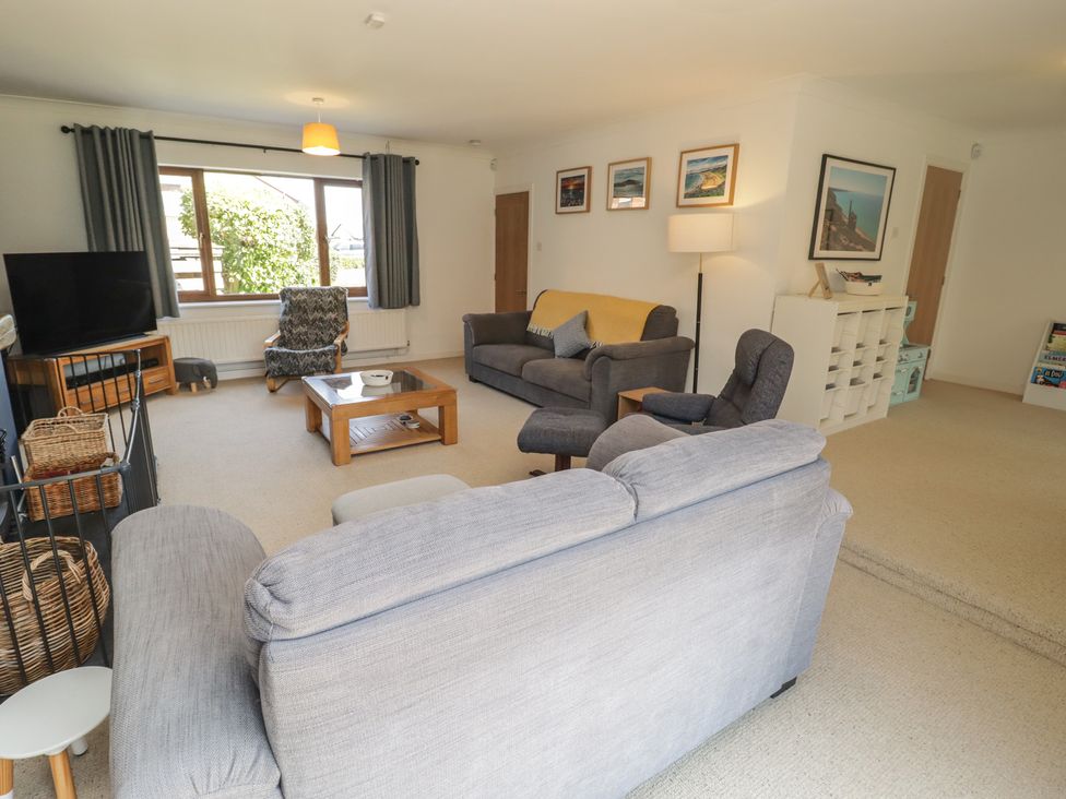 A living room with a sofa and television at Ty Traeth in Porthcawl