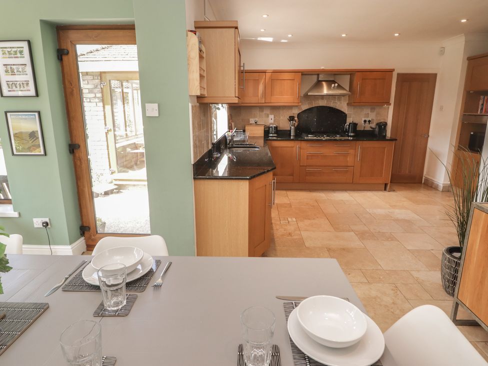 A kitchen with a table and chairs at Ty Traeth in Porthcawl