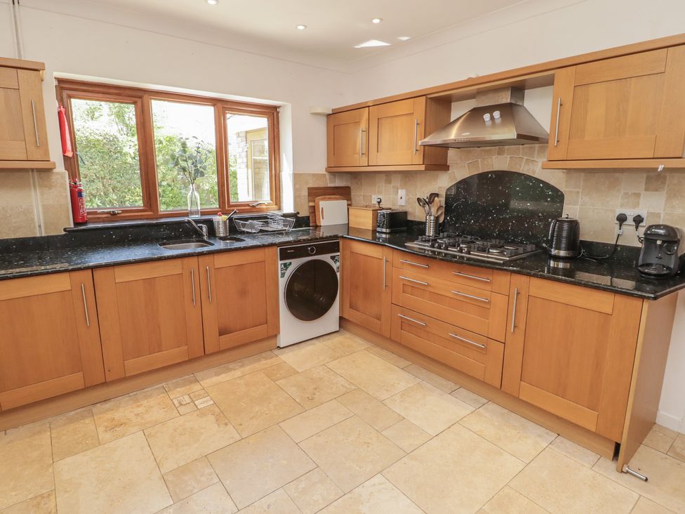A kitchen with cabinets and appliances at Ty Traeth in Porthcawl