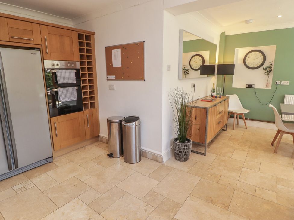 A kitchen with appliances and furniture at Ty Traeth in Porthcawl