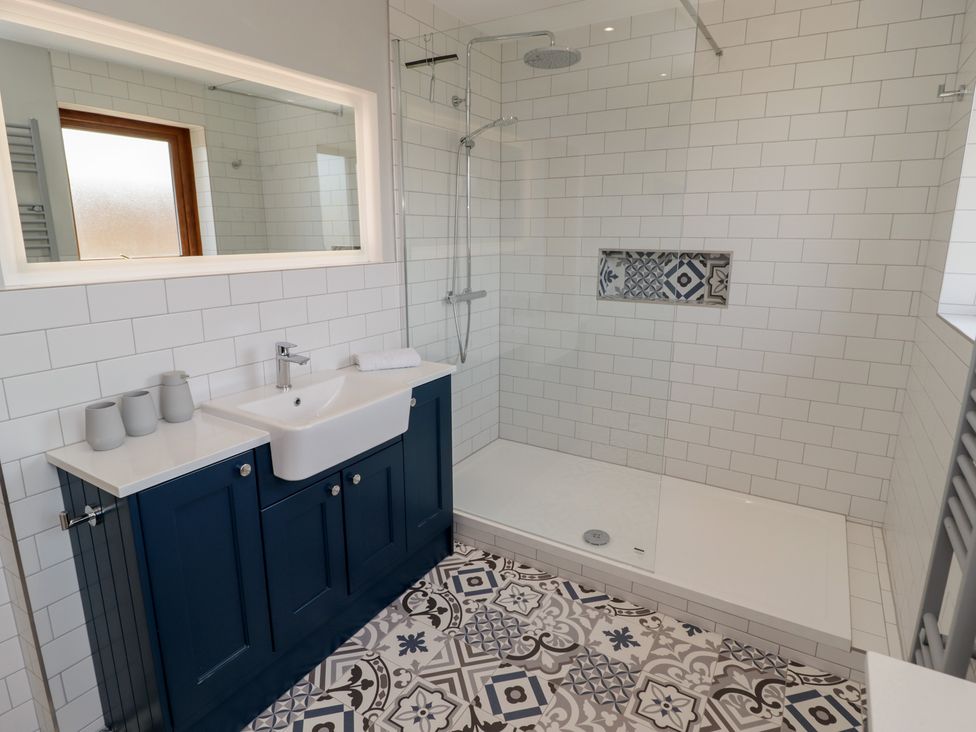 A bathroom with a sink and shower area at Ty Traeth in Porthcawl