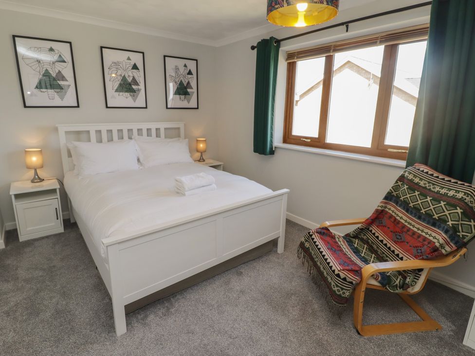 A bedroom with a bed and bedside table at Ty Traeth in Porthcawl