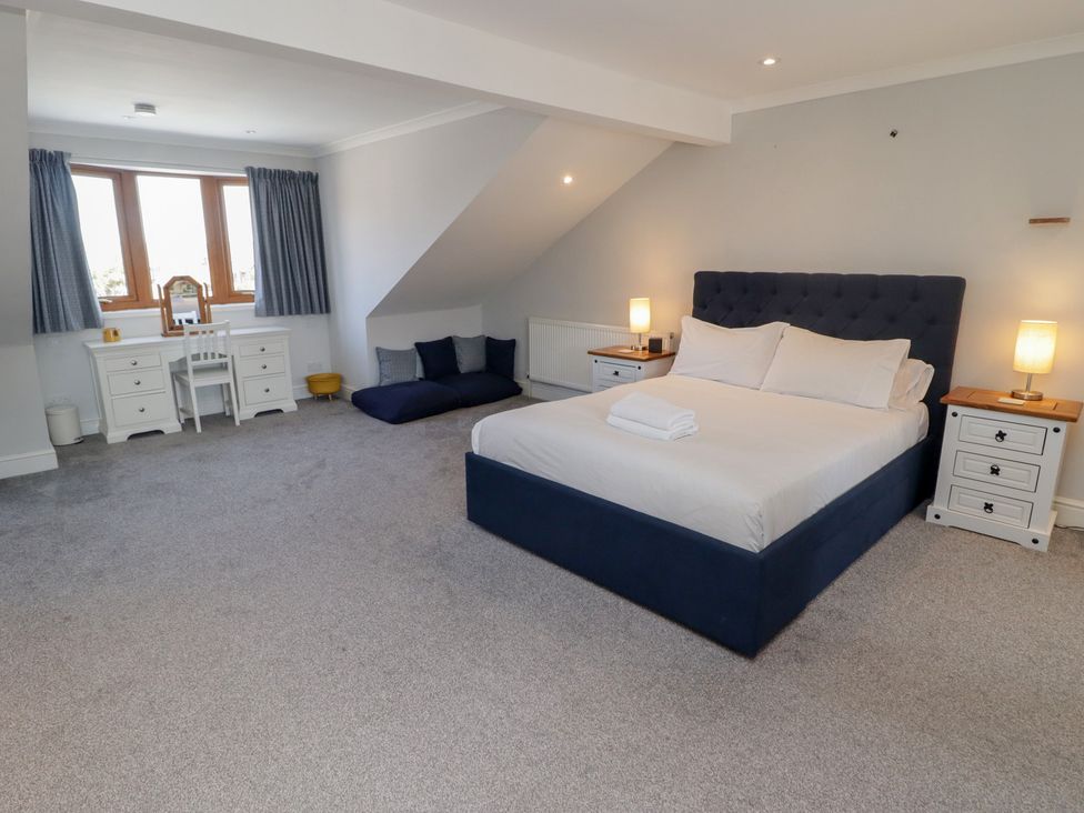 A bedroom with a bed and desk at Ty Traeth in Porthcawl