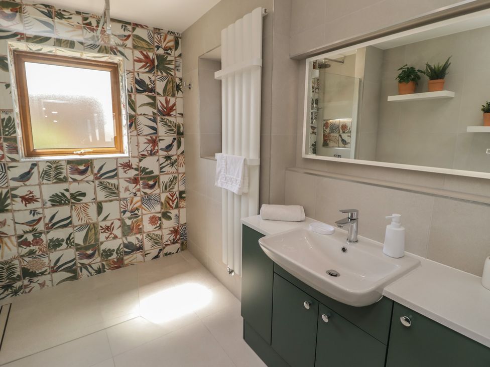 A bathroom with a sink and shower at Ty Traeth in Porthcawl