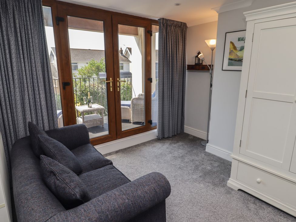 A living room with a sofa and sliding door at Ty Traeth in Porthcawl