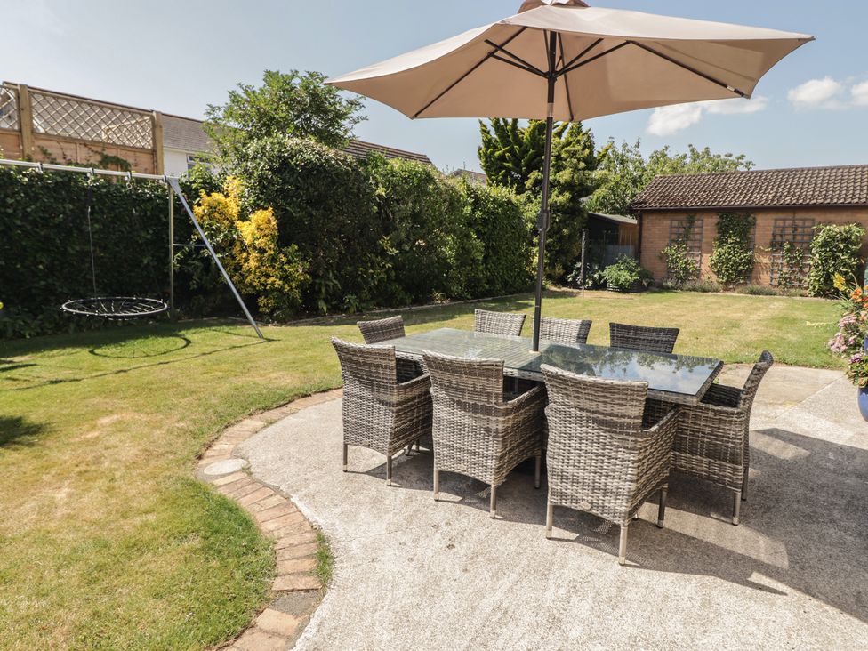 A garden with a dining area featuring a table and chairs at Ty Traeth in Porthcawl