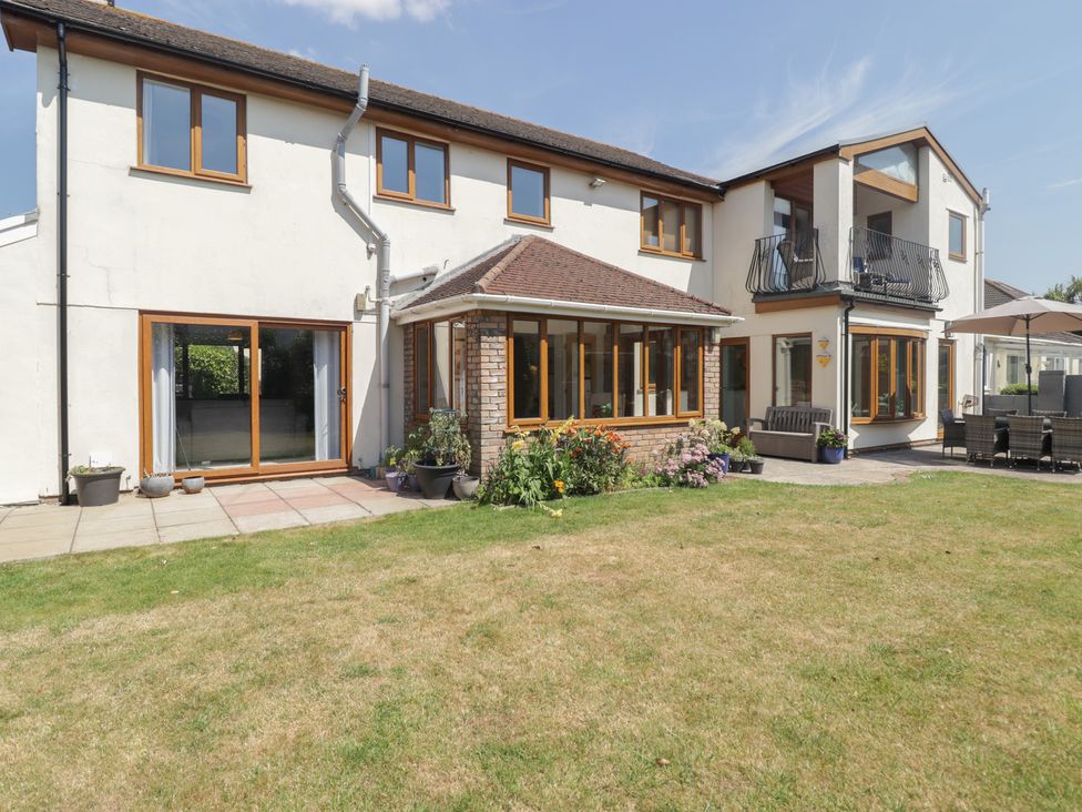 A house with a garden and patio area at Ty Traeth in Porthcawl